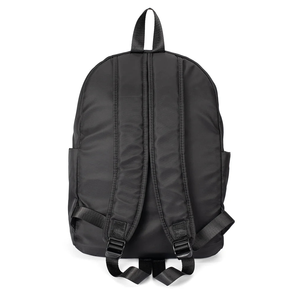Close-up detail shot of the backpack fabric, stitching, and hardware accents on the black finish.