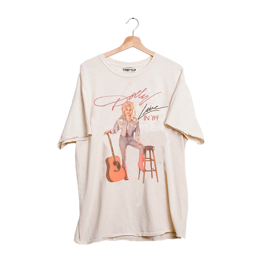 Official Dolly Parton Merchandise. This t-shirt features a vintage photo of Dolly holding an acoustic guitar.