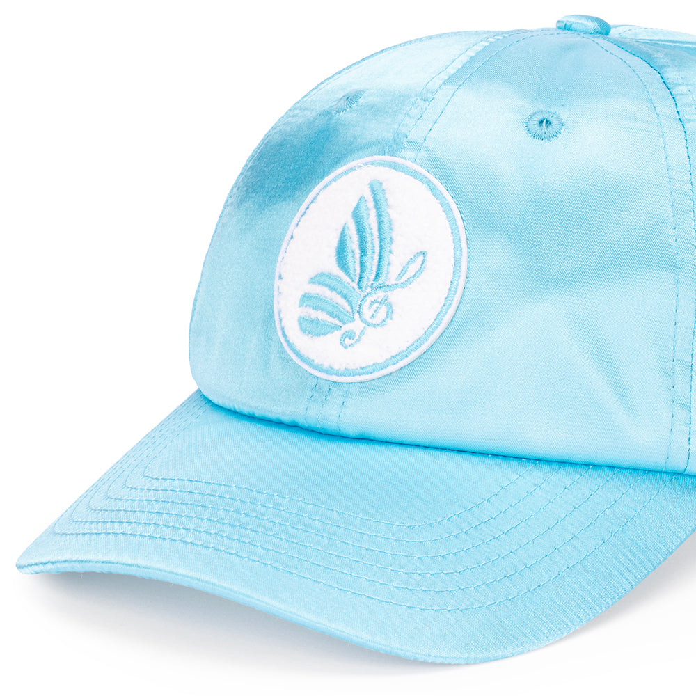 Side profile view of the Dolly Parton satin cap resting flat