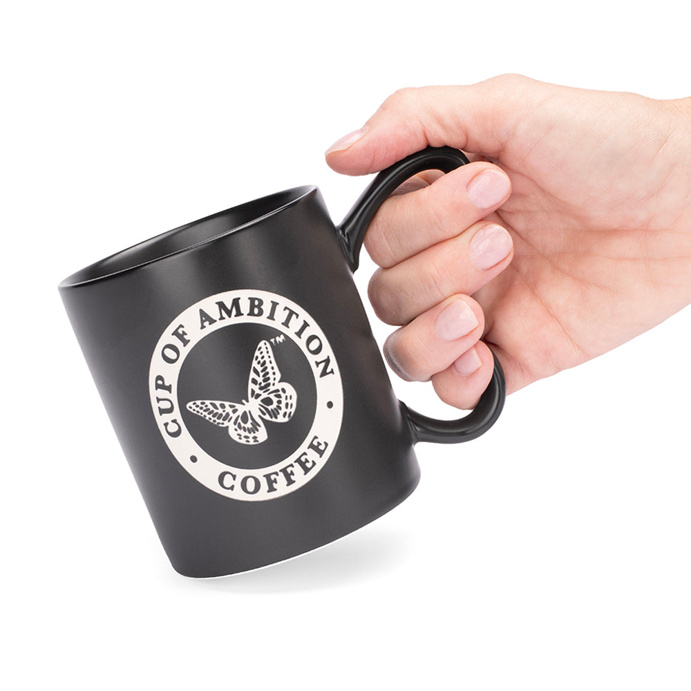 Close-up view of the laser-etched detailing on the black mug surface.
