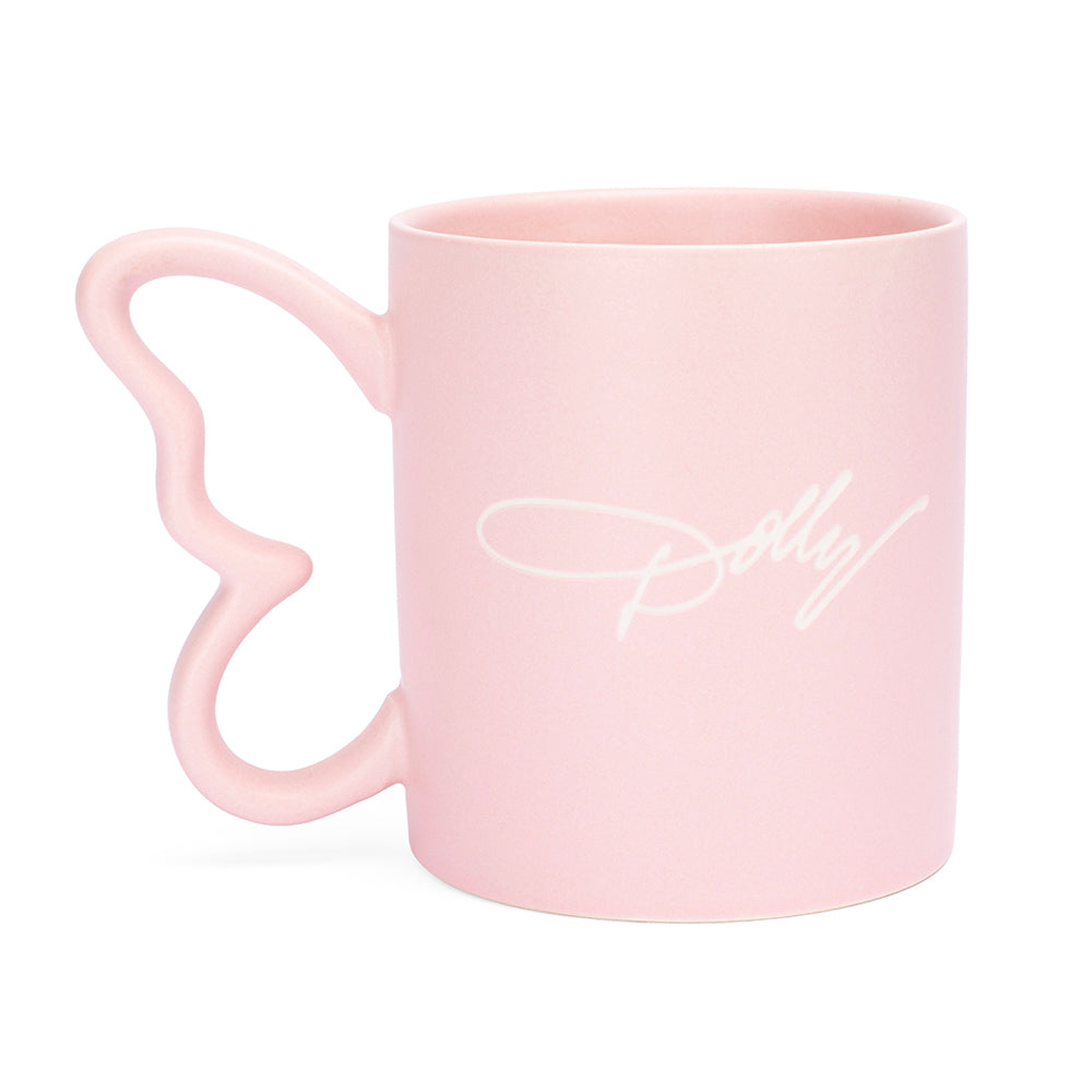 Close-up view of the sculptural butterfly handle on the pink ceramic mug