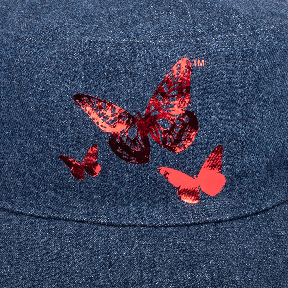 Close-up detail of the foil butterfly graphic, catching the light against the textured denim fabric