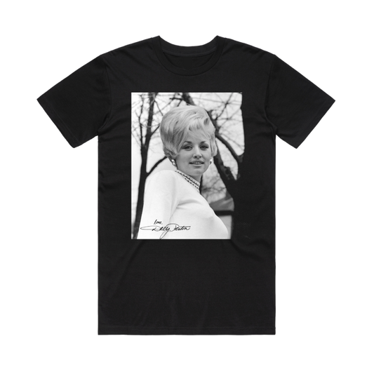 Official Dolly Parton Merchandise. 100% black premium cotton unisex t-shirt with a black and white photo of a young Dolly Parton with 60's style hair and the words "Love Dolly" on the bottom corner of the photo.